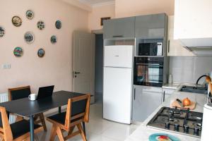 a kitchen with a table and a white refrigerator at Hostel Rioni in Kutaisi