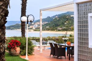 a patio with a table and chairs and a view of the ocean at Simpson Secret - Epirus Coast in Ligia