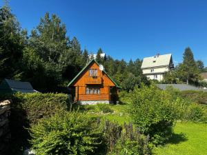 a small wooden house on a hill with trees at Chata Retro in Tatranská Lomnica