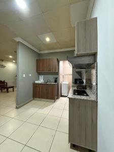 a large kitchen with wooden cabinets and a stove at Apartamentos Marconela in San Mateo