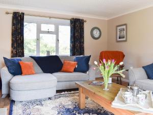 a living room with a couch and a table at Mill Lea Cottage in Leek