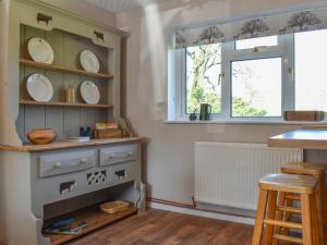 a kitchen with a shelf with plates on it at Mill Lea Cottage in Leek +23 photos