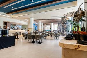 a restaurant with tables and chairs in a building at Sunshine by Villacarte in Layan Beach