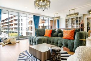 a living room with a green couch and orange pillows at Sunshine by Villacarte in Layan Beach