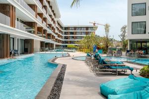 a swimming pool with chaise lounge chairs in a building at Sunshine by Villacarte in Layan Beach