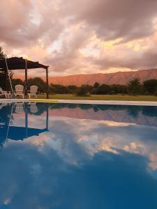 a swimming pool with chairs and a gazebo and mountains at Rancho La Peregrina in Nono