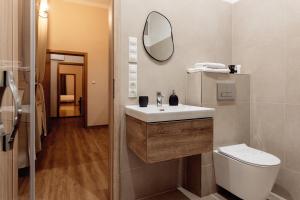 a bathroom with a sink and a toilet and a mirror at City Residence Apartment Hotel in Košice