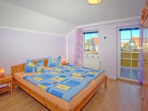 a bedroom with a large bed with blue comforter at Villa Lisa in Glowe
