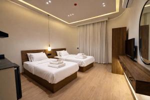a hotel room with two beds and a flat screen tv at Cairo Stays Hotel in Cairo
