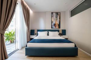a bedroom with a bed and a large window at Hotel Vino in Durrës