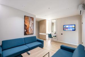a living room with a blue couch and a table at Hotel Vino in Durrës