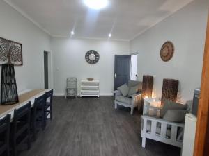 a living room with white walls and a table and chairs at Gables B&B Guesthouse in George