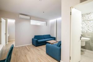 a living room with a blue couch and a table at Hotel Vino in Durrës +54 photos