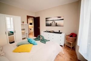 a bedroom with a white bed with a dresser and a dresser at Aura Apartment - VISTA LAGO - CENTRO STORICO in Bracciano