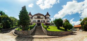 a large house with stairs in front of it at Chateau Palace Hotel in São Lourenço