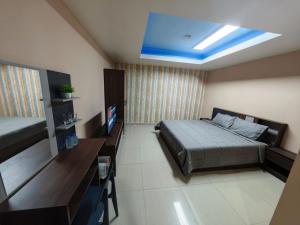 a bedroom with a bed and a television in it at Blue Apartment in Pattaya