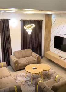 a living room with a couch and a table at Living Space Home in Lekki