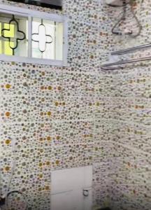 a bathroom with a window and a tiled wall at Living Space Home in Lekki