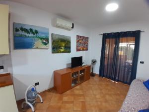 a living room with a television on a wooden cabinet at Palm Beach Resort in Boca Chica