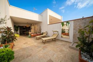 a patio of a house with chairs and plants at La Dimora del Sole in Monopoli