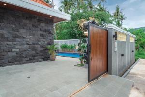 an open door of a house with a patio at Villa Chandra Lovina in Lovina