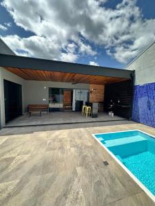 an outdoor patio with a swimming pool and a house at Casa 2min do Centro & Piscina in Bonito