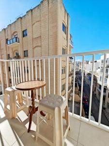 a balcony with a table and chairs and a view of a city at Good Times in Sliema