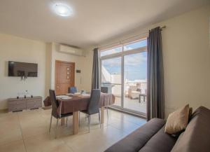 a living room with a table and a dining room at The Terrace in Xgħajra