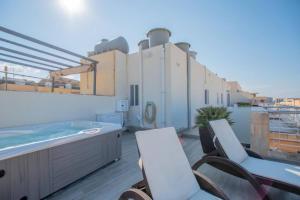 a balcony with chairs and a hot tub on a building at The Terrace in Xgħajra