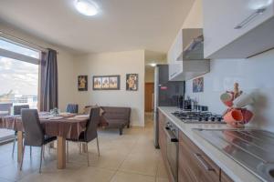 a kitchen and dining room with a table and a stove at The Terrace in Xgħajra