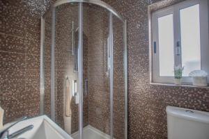 a bathroom with a shower and a toilet and a window at The Terrace in Xgħajra +15 photos