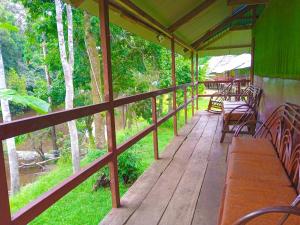 a wooden porch with tables and chairs on it at Amazon Bromelia Lodge & Expeditions in Iquitos