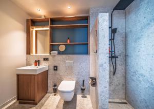 a bathroom with a toilet and a sink and a shower at The Zipper Hotel und Apartments in Düsseldorf