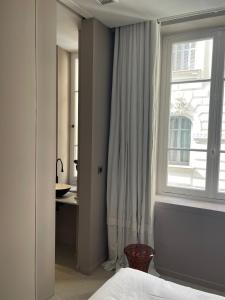 a bedroom with a bed and a window and a desk at Chambre Gounod in Nice +6 photos