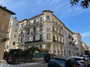 a large white building with cars parked in front of it at Chambre Gounod in Nice