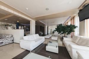 a living room with white furniture and a flat screen tv at Hotel Villa Pace in Međugorje