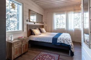 a bedroom with a bed and two windows at Villa Happy Fox in Rovaniemi