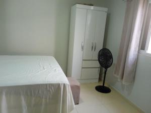 a bedroom with a white bed and a fan at Casa do Descanso in Triunfo