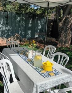 a white table with white chairs and an umbrella at Casa de Limon - צימרים וסוויטות בוטיק בגליל in Sede Eli‘ezer