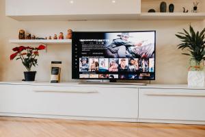 a flat screen tv on top of a white cabinet at I due ponti in Molfetta