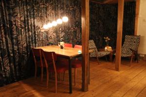 a dining room with a wooden table and chairs at The charming, bright stable in Neuilly-le-Dien +11 photos