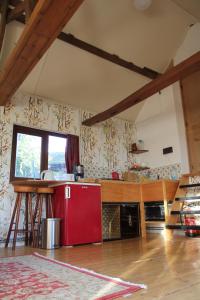a kitchen with a red refrigerator in a room at The charming, bright stable in Neuilly-le-Dien