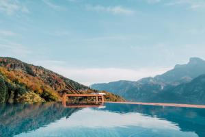 a lake in the mountains with a bridge in the water at Mondseeblick Apartment KG in Innerschwand +154 photos