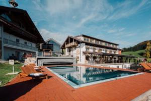 a building with a swimming pool in front of a building at Mondseeblick Apartment KG in Innerschwand