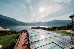 a glass house with a view of a lake and mountains at Mondseeblick Apartment KG in Innerschwand