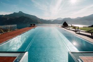 a swimming pool with a view of a lake and mountains at Mondseeblick Apartment KG in Innerschwand