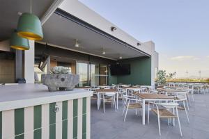 a restaurant with tables and chairs on a patio at WorldHotels Guadalajara Zona Andares in Guadalajara