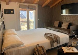 a bedroom with a bed and a couch and a window at Hotel Isola Verde in Nago-Torbole +124 photos