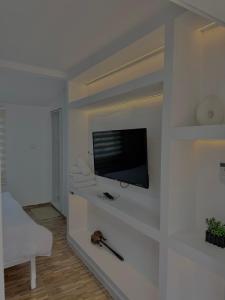 a living room with a flat screen tv on a wall at VilaBakiaj in Tepelenë