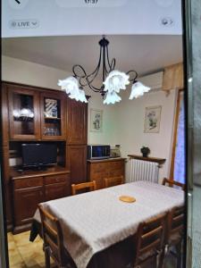 a dining room with a table and a chandelier at appartamento yuliet in Città di Castello